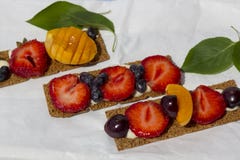 Здоровые и вкусные тосты с сыром, плодами и ягодами творога на белой пергаментной бумаге стоковые фотографии rf Здоровые и вкусные тосты с сыром, плодами и ягодами творога на белой пергаментной бумаге стоковые фотографии rf