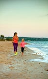 Здоровые мать и дочь на береге моря в jogging вечера Стоковое фото RF Здоровые мать и дочь на береге моря в jogging вечера Стоковое фото RF