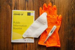 image photo : Galway / Ireland - 04/03/2020 Irish Health and service Coronavirus COVID - 19 booklet, thermometer, face mask and rubber gloves on