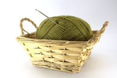 Зеленый путать естественных шерстей для needlework с вязать крючком крючком вязанием крючком вставил в ем в плетеной корзине на б стоковое фото rf Зеленый путать естественных шерстей для needlework с вязать крючком крючком вязанием крючком вставил в ем в плетеной корзине на б стоковое фото rf