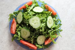 Зеленый свет и вкусный салат с arugula, огурцом и томатом стоковые фотографии rf Зеленый свет и вкусный салат с arugula, огурцом и томатом стоковые фотографии rf