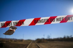 Зона опасности красная и белая ленты баррикады зоны отчуждения с написанным утвержденным входом персонала только на след поезда стоковое изображение rf Зона опасности красная и белая ленты баррикады зоны отчуждения с написанным утвержденным входом персонала только на след поезда стоковое изображение rf