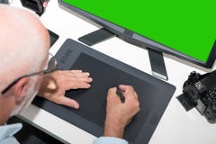 Зрелый человек работая с таблеткой графиков в офисе стоковые изображения Зрелый человек работая с таблеткой графиков в офисе стоковые изображения
