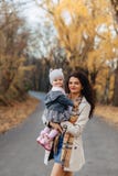 Игра мамы молодой женщины с меньшей дочерью на дороге парка осени стоковые фотографии rf Игра мамы молодой женщины с меньшей дочерью на дороге парка осени стоковые фотографии rf