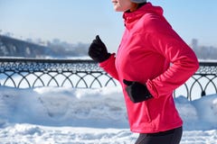 Идущая женщина спорта Женский бегун jogging в холодном городе зимы нося теплые sporty идущие одежду и перчатки стоковая фотография rf Идущая женщина спорта Женский бегун jogging в холодном городе зимы нося теплые sporty идущие одежду и перчатки стоковая фотография rf