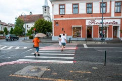 Идущие люди на пешеходном переходе в дожде стоковое фото Идущие люди на пешеходном переходе в дожде стоковое фото