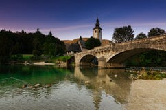 Известный взгляд на церков и мосте на озере Bohinj, Словении стоковое изображение rf Известный взгляд на церков и мосте на озере Bohinj, Словении стоковое изображение rf