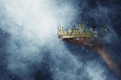 Изображение Mysteriousand волшебное руки ` s женщины держа крону золота над готической черной предпосылкой средневековая концепци стоковые изображения rf Изображение Mysteriousand волшебное руки ` s женщины держа крону золота над готической черной предпосылкой средневековая концепци стоковые изображения rf