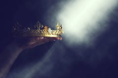 Изображение Mysteriousand волшебное руки ` s женщины держа крону золота над готической черной предпосылкой средневековая концепци стоковые фотографии rf Изображение Mysteriousand волшебное руки ` s женщины держа крону золота над готической черной предпосылкой средневековая концепци стоковые фотографии rf