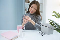 Изображение девушки красоты которое положило некоторую из сливк руки на ее руку и тереть ее Она делает что тщательный и нежный стоковая фотография rf Изображение девушки красоты которое положило некоторую из сливк руки на ее руку и тереть ее Она делает что тщательный и нежный стоковая фотография rf