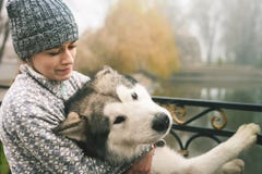 Изображение маленькой девочки обнимает ее собаку, маламута, внешний стоковая фотография Изображение маленькой девочки обнимает ее собаку, маламута, внешний стоковая фотография