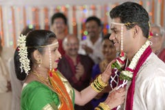 Индийская индусская невеста смотря groom и обменивая гирлянду в свадьбе махарастры стоковое изображение rf Индийская индусская невеста смотря groom и обменивая гирлянду в свадьбе махарастры стоковое изображение rf