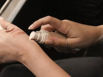 Испытывать студента маленькой девочки, прикладывая учреждение на ее руках в парфюмерии стоковое изображение Испытывать студента маленькой девочки, прикладывая учреждение на ее руках в парфюмерии стоковое изображение