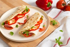 Итальянское piadina на белой плите с томатами и перцем овощей на белой предпосылке E Взгляд со стороны, космос экземпляра стоковое фото Итальянское piadina на белой плите с томатами и перцем овощей на белой предпосылке E Взгляд со стороны, космос экземпляра стоковое фото