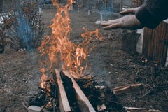 Кавказский человек грея его руки на лагерном костере в холодной темной атмосфере стоковое фото rf Кавказский человек грея его руки на лагерном костере в холодной темной атмосфере стоковое фото rf
