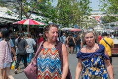 Кажется, что будут 2 дамы westerner зрелых другом идя и говоря совместно в рынке выходных Chatuchak стоковые изображения rf Кажется, что будут 2 дамы westerner зрелых другом идя и говоря совместно в рынке выходных Chatuchak стоковые изображения rf