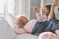 Как раз одна больше минуты в кровати? Милая маленькая девочка просыпая вверх ее щеголь стоковые фото Как раз одна больше минуты в кровати? Милая маленькая девочка просыпая вверх ее щеголь стоковые фото