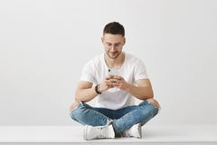 Какой внушительный app я загрузил Студия сняла привлекательного молодого сотрудника сидя в ультрамодном обмундировании на поле с стоковые фото Какой внушительный app я загрузил Студия сняла привлекательного молодого сотрудника сидя в ультрамодном обмундировании на поле с стоковые фото
