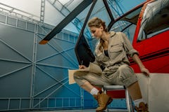 Карта чтения пилота или механика вертолета молодой женщины Вертолетное крушение стоковое изображение rf Карта чтения пилота или механика вертолета молодой женщины Вертолетное крушение стоковое изображение rf