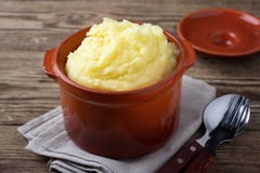 Картофельные пюре в глиняном горшке, винтажная деревянная предпосылка стоковая фотография rf Картофельные пюре в глиняном горшке, винтажная деревянная предпосылка стоковая фотография rf