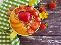 Каша овсяной каши, абрикос, клубника, сердце завтрака на деревянной предпосылке стоковые изображения rf Каша овсяной каши, абрикос, клубника, сердце завтрака на деревянной предпосылке стоковые изображения rf