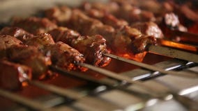 Кашевар жарит в духовке сочное барбекю kebab с кудрявым Кашевар жарит в духовке сочное барбекю kebab с кудрявым