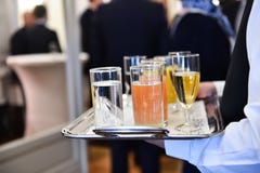 Кельнер держа поднос с напитками во время партии коктеиля стоковое изображение rf Кельнер держа поднос с напитками во время партии коктеиля стоковое изображение rf