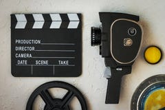 Киносъемочный аппарат, clapperboard, коробка фильма и желтый фильтр стоковая фотография Киносъемочный аппарат, clapperboard, коробка фильма и желтый фильтр стоковая фотография