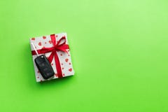 Ключ автомобиля на бумажной подарочной коробке с красным смычком ленты и сердце на предпосылке зеленой таблицы Праздники представ стоковая фотография rf Ключ автомобиля на бумажной подарочной коробке с красным смычком ленты и сердце на предпосылке зеленой таблицы Праздники представ стоковая фотография rf