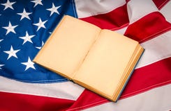 Книга года сбора винограда открытая на американском флаге Стоковые Фото Книга года сбора винограда открытая на американском флаге Стоковые Фото