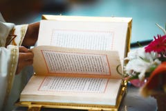 Книга Евангелия открыта для читать в руках священника на свадьбе стоковое фото Книга Евангелия открыта для читать в руках священника на свадьбе стоковое фото