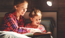 Книга чтения матери и ребенка в кровати перед идти спать Стоковое Изображение RF Книга чтения матери и ребенка в кровати перед идти спать Стоковое Изображение RF