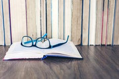 Книги Hardback на белом деревянном столе, открытой книге и стеклах, космосе экземпляра для текста стоковое фото rf Книги Hardback на белом деревянном столе, открытой книге и стеклах, космосе экземпляра для текста стоковое фото rf