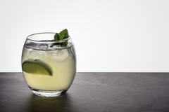 Коктейль mojito в небольшом овальном стекле гарнированном с мятой и известкой на каменном основании утеса и назад освещенной пред стоковое фото Коктейль mojito в небольшом овальном стекле гарнированном с мятой и известкой на каменном основании утеса и назад освещенной пред стоковое фото