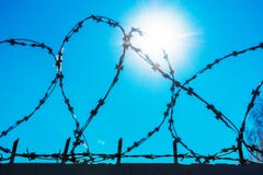 Колючая проволока против голубого неба стоковое фото rf Колючая проволока против голубого неба стоковое фото rf