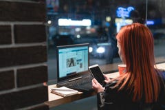 Коммерсантка, девушка работая на ноутбуке в кафе, смартфоне в руках, ручке владением, телефоне пользы r Онлайн, стоковые изображения Коммерсантка, девушка работая на ноутбуке в кафе, смартфоне в руках, ручке владением, телефоне пользы r Онлайн, стоковые изображения