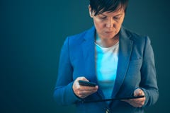 Коммерсантка используя мобильный телефон и планшет стоковые изображения rf Коммерсантка используя мобильный телефон и планшет стоковые изображения rf