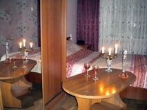 Комната с тусклой светлой таблицей со свечами и рябиновкой стоковые изображения rf Комната с тусклой светлой таблицей со свечами и рябиновкой стоковые изображения rf
