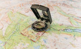 Компас на карте для находить путь в глуши и жизни стоковые изображения Компас на карте для находить путь в глуши и жизни стоковые изображения