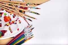 Комплект щеток искусства, мольберта и белой бумаги на деревянном столе в мастерской ` s художника Стоковые Изображения RF Комплект щеток искусства, мольберта и белой бумаги на деревянном столе в мастерской ` s художника Стоковые Изображения RF
