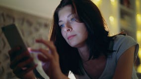 Конец-вверх детенышей сконцентрировал женщину имея наркоманию и инсомнию интернета используя smartphone лежа в кровати дома на сток-видео Конец-вверх детенышей сконцентрировал женщину имея наркоманию и инсомнию интернета используя smartphone лежа в кровати дома на сток-видео
