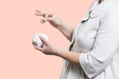 Конец-вверх женщины кладет монетку в копилку Концепция денег Econom стоковое фото rf Конец-вверх женщины кладет монетку в копилку Концепция денег Econom стоковое фото rf