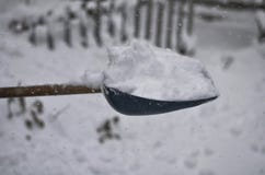 Конец-вверх лопаткоулавливателя снега После сильного снегопада, человек убирает двор от смещений снега стоковое изображение rf Конец-вверх лопаткоулавливателя снега После сильного снегопада, человек убирает двор от смещений снега стоковое изображение rf
