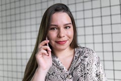 Конец вверх по молодой женщине офиса говоря с кто-то по ее телефону смотря в камеру стоковые изображения Конец вверх по молодой женщине офиса говоря с кто-то по ее телефону смотря в камеру стоковые изображения