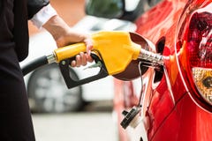 Конец-вверх танка ` s автомобиля руки ` s коммерсантки дозаправляя Стоковые Изображения RF Конец-вверх танка ` s автомобиля руки ` s коммерсантки дозаправляя Стоковые Изображения RF