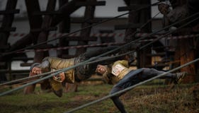 Конкуренты падая от веревочек на крутой парень гонке 2014 препятствия стоковое изображение Конкуренты падая от веревочек на крутой парень гонке 2014 препятствия стоковое изображение