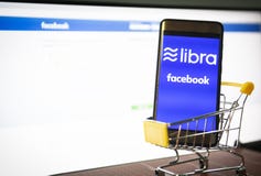 Концепция blockchain монетки Libra со смартфоном на корзине/новом libra проекта cryptocurrency запущенное Facebook смотрит к стоковое изображение rf Концепция blockchain монетки Libra со смартфоном на корзине/новом libra проекта cryptocurrency запущенное Facebook смотрит к стоковое изображение rf