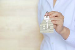 Концепция агента недвижимости, ключ удерживания руки женщины с keychain в форме дома стоковые изображения rf Концепция агента недвижимости, ключ удерживания руки женщины с keychain в форме дома стоковые изображения rf