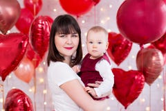 Концепция дня Валентайн - счастливая красивая женщина с дочерью над красной в форме сердц предпосылкой воздушных шаров стоковое фото Концепция дня Валентайн - счастливая красивая женщина с дочерью над красной в форме сердц предпосылкой воздушных шаров стоковое фото