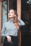 Концепция моды улицы: портрет элегантной молодой красивой женщины представляя около двери Талия вверх детеныши женщины уклада жиз стоковое изображение rf Концепция моды улицы: портрет элегантной молодой красивой женщины представляя около двери Талия вверх детеныши женщины уклада жиз стоковое изображение rf